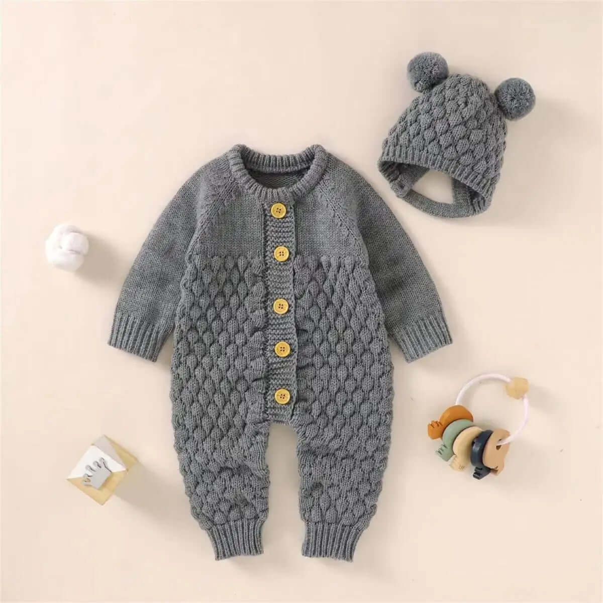 Grey knitted romper with bear ear hat and button closure, featuring a cozy design for babies aged 0-24 months.