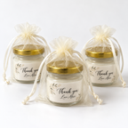 Personalised 50ml Mini Soy Wax Candles in clear glass jars with gold lids, floral thank-you labels and ivory organza bags.